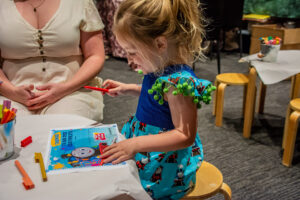 Young Girl Receives Help From Mum To Write Her Name On Her Junior Engineer Certificate