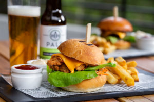 CLASSIC BEEF BURGER - 180g of char grilled beef with cos lettuce, dill pickles, white onion and American cheese, topped with burger sauce and ketchup, served with fries.