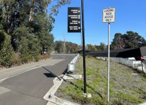 Road sign showing the directions to two accessible car parking areas as well as a public car park.