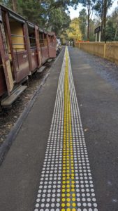 Tactile Ground Surface Indicators At Puffing Billy's Lakeside Station Platform With Open Side Carriages Visible.