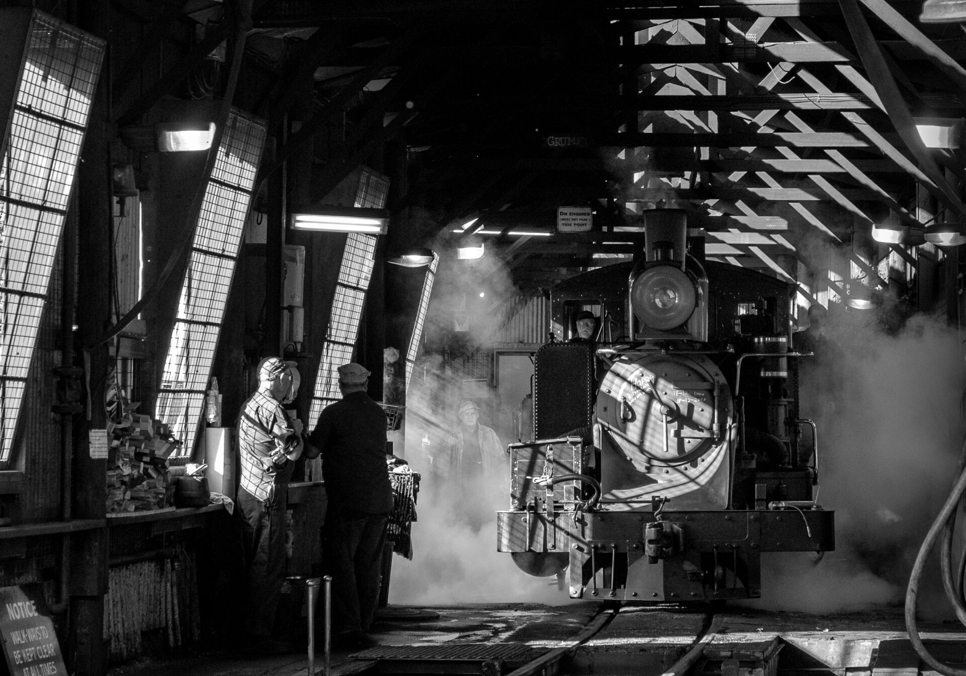 With early morning light pouring in through the windows, the crew of 8A propel it forward with a burst of steam towards the doors at the front of the running shed on the day of the railway's 119th birthday.