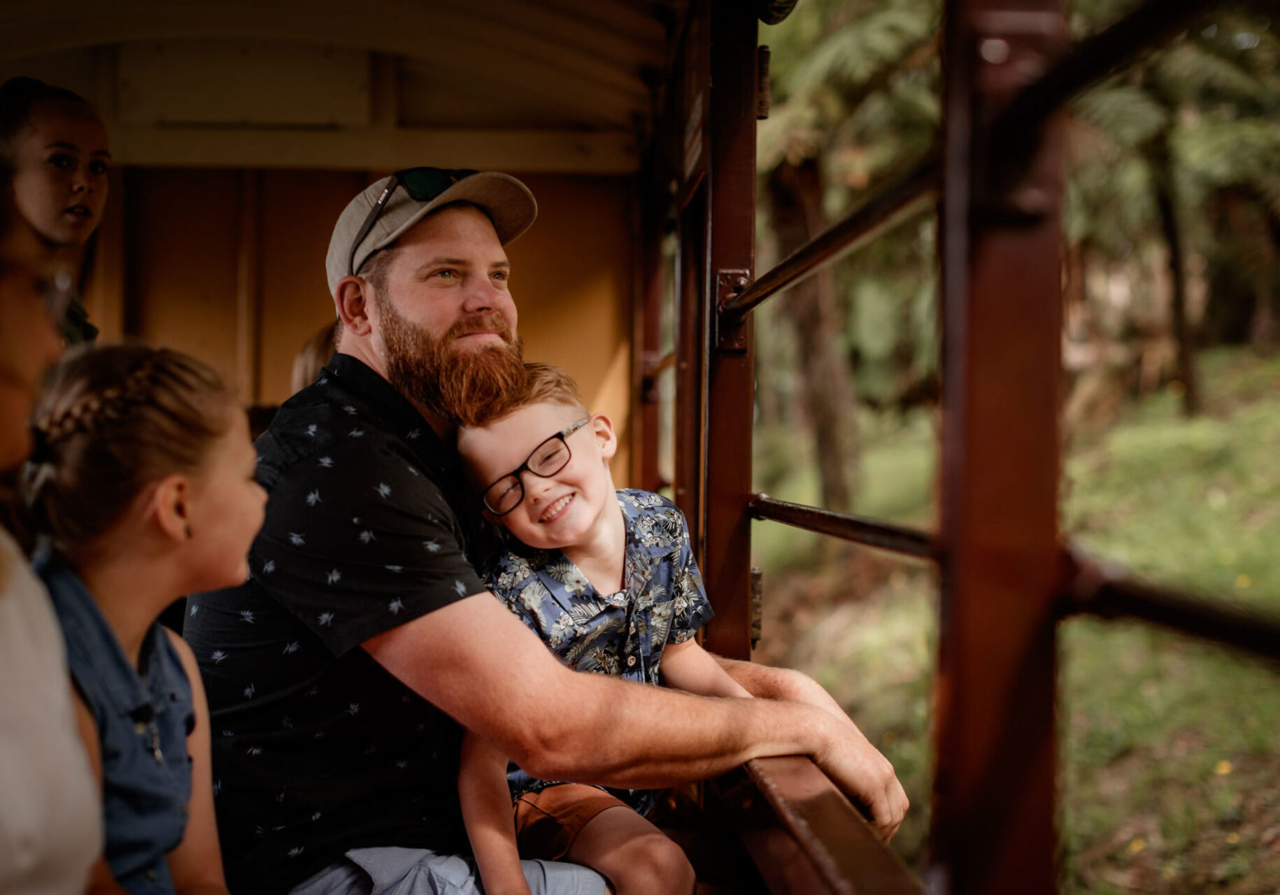 Father And Son Sitting And Looking At Views Of Forest