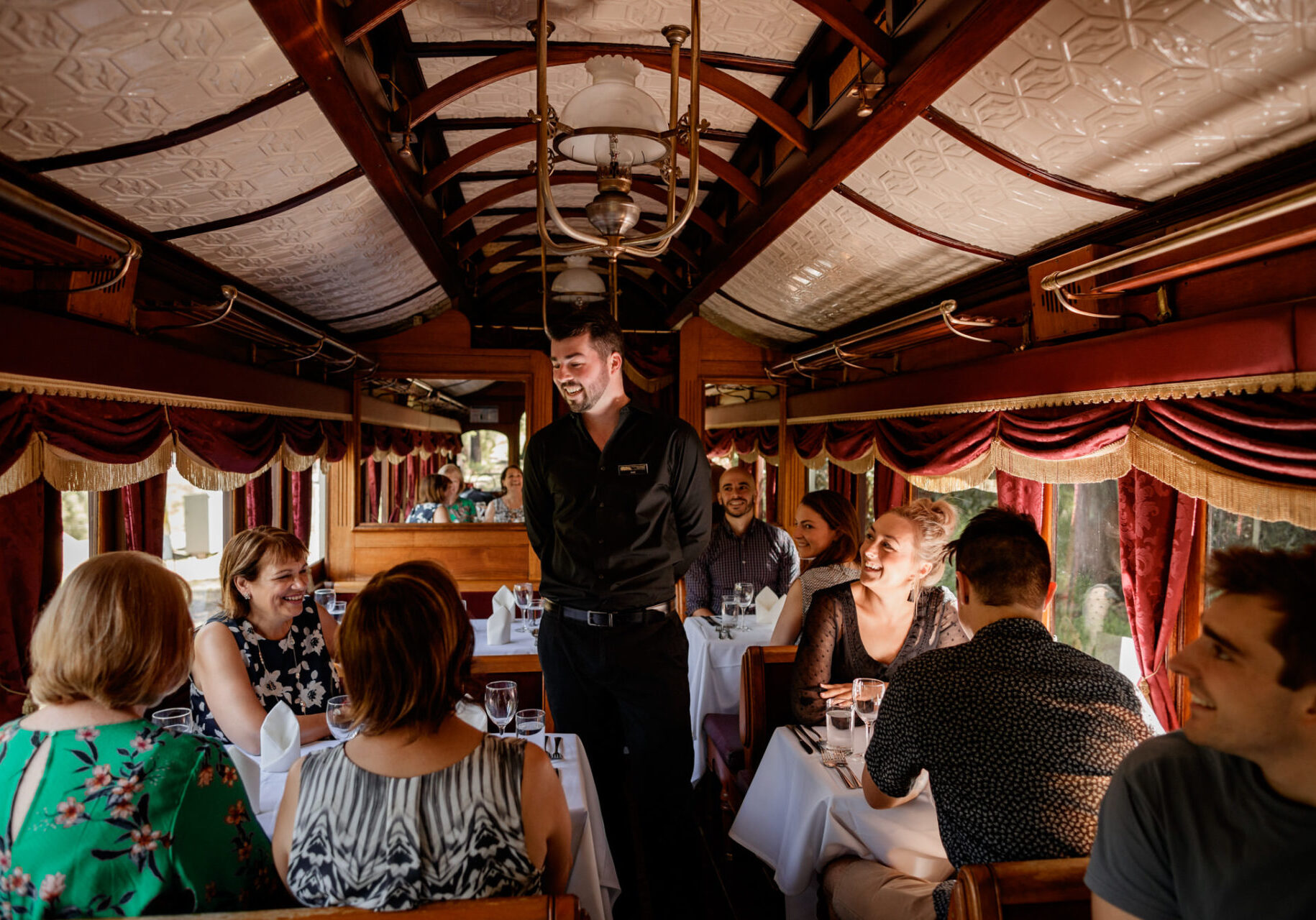 Server Talking To Guests On Board Dining Carriage
