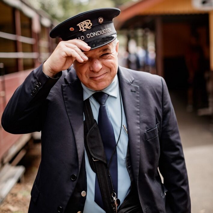 Volunteer Conductor At Lakeside Station Tipping Hat On Platform